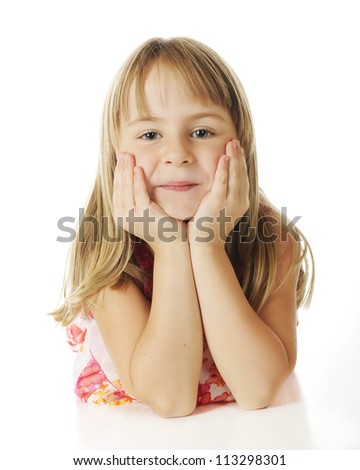 Straight on view of a pretty young elementary girl looking at the viewer while propping her head in her hands.  On a white background.