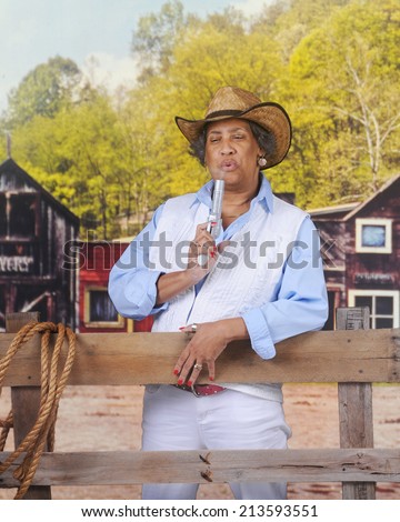 A mature African American Cowgirl in an old western town, blowing smoke off her gun.