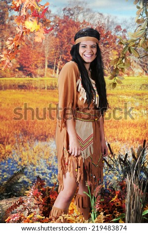An attractive Indian teen scrunched up and laughing as she looks at the viewer from the wetlands.