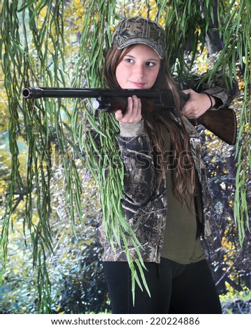 A pretty teen hunter preparing to aim her rifle.