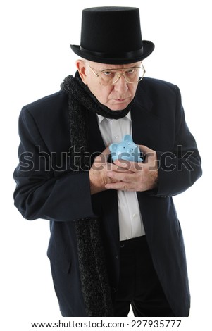 A grumpy old man in a top hat clinging miserly to his blue piggy bank.  On a white background.