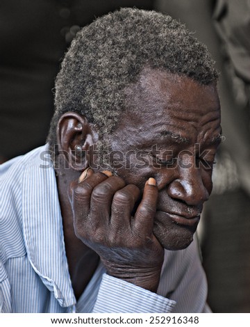 BOIS NEUS, HAITI - FEBRUARY 9, 2014:  Closeup of an elderly man sleeping (or praying) during a Christian church service in Haiti.