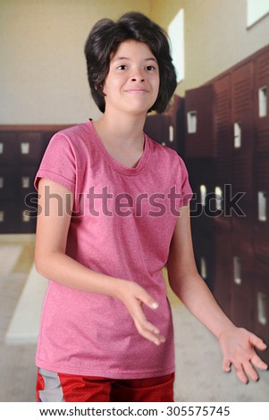 A pretty young teen anticipating a tossed ball in her school locker room.  Motion blur on her hands.