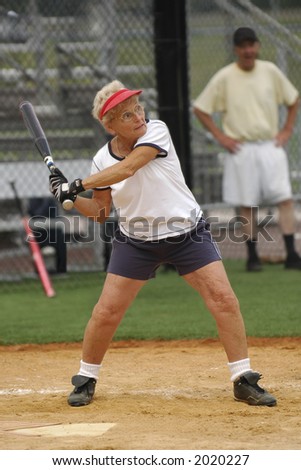 Senior woman at bat in softball game.