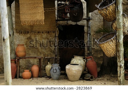 Ancient domestic scene with vintage pottery and hanging baskets (replicas).  Horizontal.