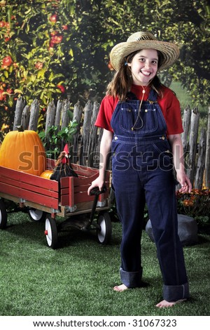 stock photo A happy barefoot girl pulling a wagon with pumpkins and a 