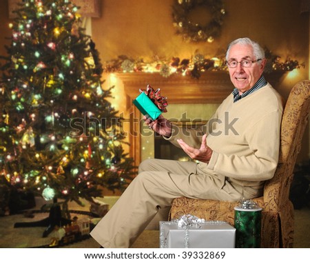A senior man in a decorated living room wondering about a wrapped gift he holds.