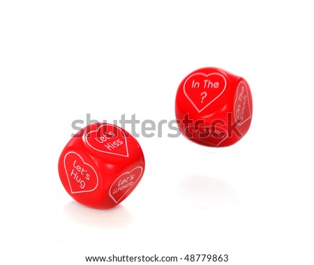 Two red dice with things to do and where to do it enclosed in heart shapes.  Isolated on white.  Motion blur on second dice.