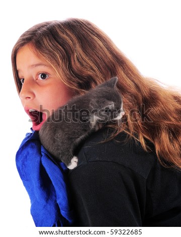 stock photo A preteen girl suddenly surprised as her tiny kitten digs in a