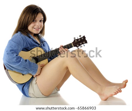 stock photo A happy beautiful young teen sitting barefoot on the floor 