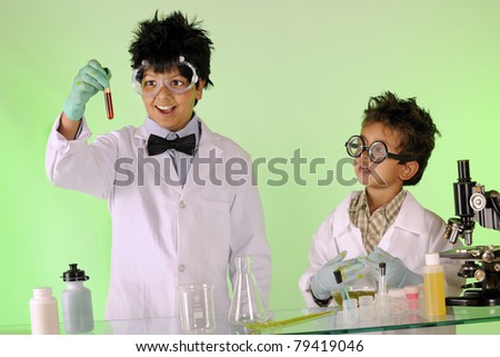 A preteen and preschool brother working as mad scientists with lab equipment.