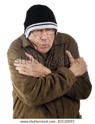 A senior man in ski cap and thin jacket shivering from the cold.