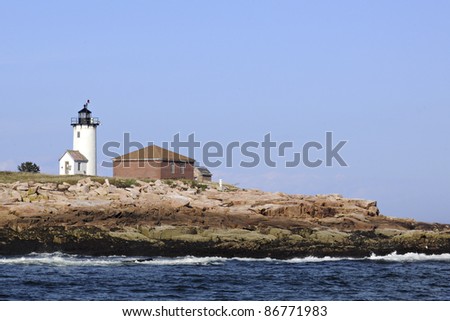 A lighthouse turned biological research station on a rocky island near Mt. Dessert Island, ME as viewed from the water.