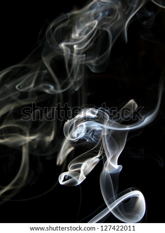 abstract spots and figures formed by smoke, black background.