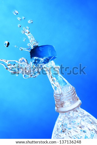 a jet of water from a bottle, beating in the discarded cover photo on a colorful background.
