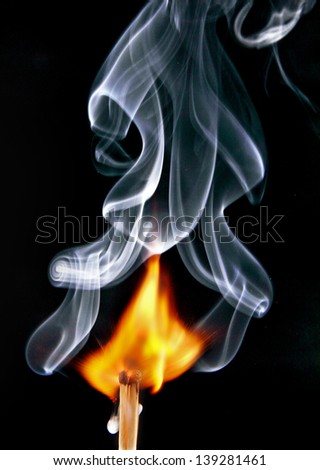 burning matches, fire, and smoke curls, photo on black background.