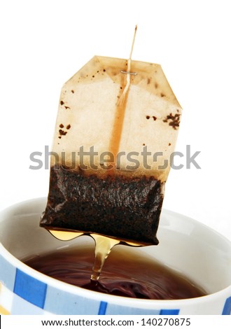 cup of tea and tea bag, tea drops falling into the cup.