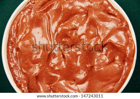 porcelain cup filled with soft chocolate, photo on a colorful background.