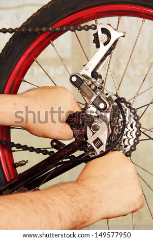 hand of the master with a wrench, repair a bicycle wheel.