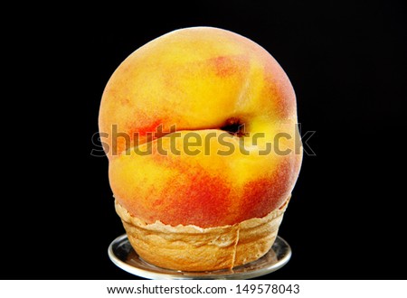 large ripe peach in a little tart, a photo on a black background.