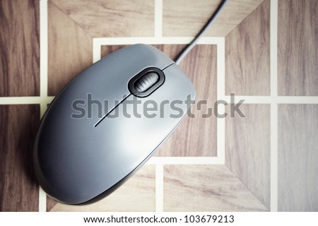 Black computer mouse isolated on geometric decorative wooden table background