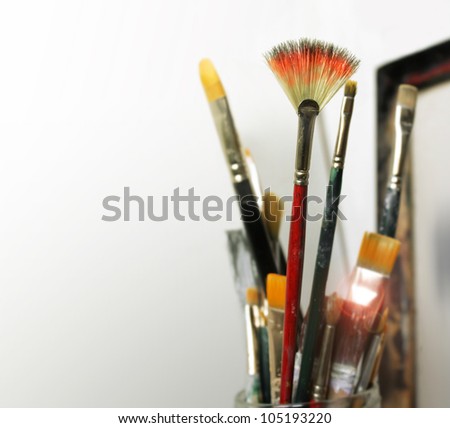 A group of artist paint brushes in modern white studio space