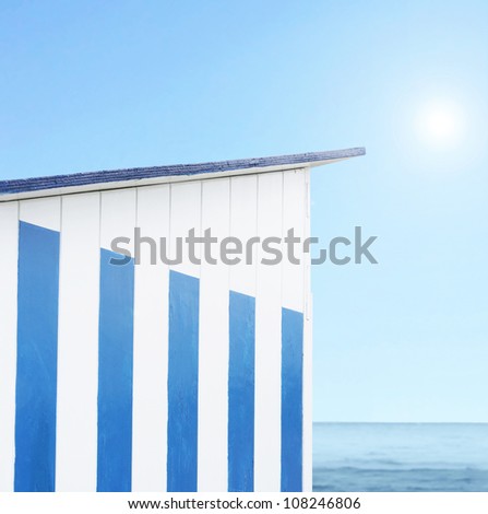 Detail of a cabin beach with sea, blue light and sun on the background
