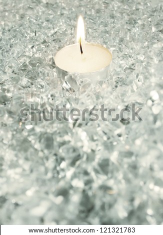 Detail of a circular candle with flame in a icy decoration