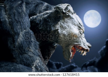 Werewolf in the night with moon and clouds on the background