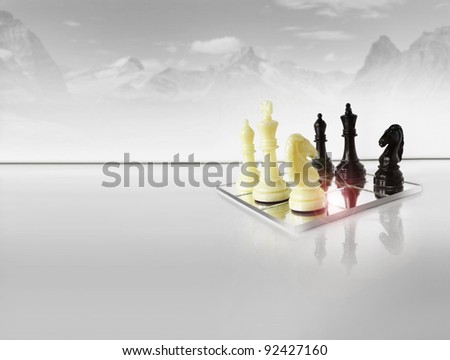 Chess pieces on white reflective foreground with abstract winter mountain scape in background
