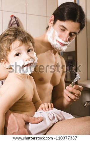 Portrait of son and father enjoying while shaving together