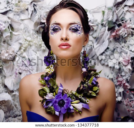 floral face art with anemone in jewelry, sensual young brunette woman