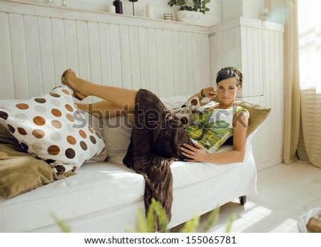 young pretty brunette woman at home laying on sofa