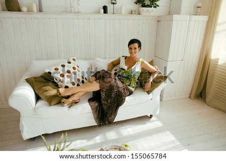 young pretty brunette woman at home laying on sofa