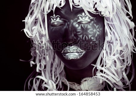 creative make up like Ethiopian mask, white pattern on black face close up