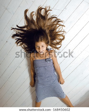 little cute girl at home laying on floor hair messed