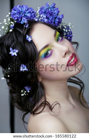Beauty young woman with flowers and make up close up, real spring beauty