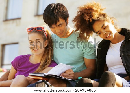 cute group of teenages at the building of university with books huggings, diversity nations