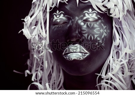 creative make up like Ethiopian mask, white pattern on black face close up, halloween horror