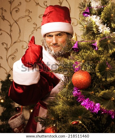 portrait of funny Santa Claus at home with christmass tree
