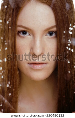 red hair woman with drops on her face, sad at windows, rain outside