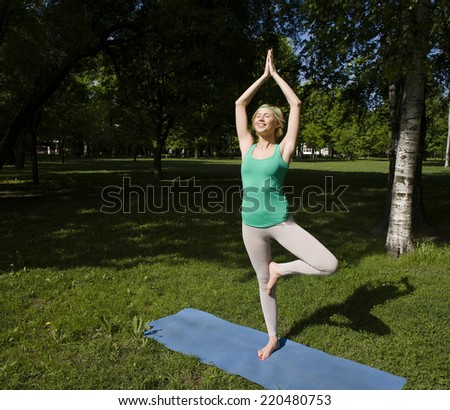 blonde girl doing yoga in green park
