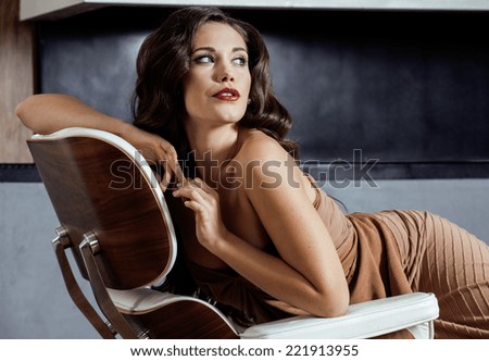 beauty yong brunette woman sitting near fireplace at home, winter warm evening in interior