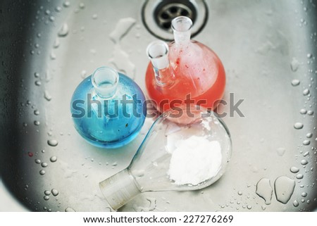 waste products in laboratory, medicine-glass with colored red and blue liquid close up