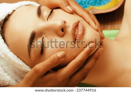 stock photo attractive lady getting spa treatment in salon, close up asian tan hands on face