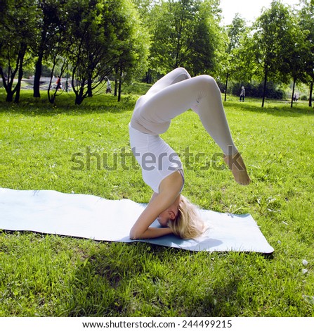 blonde real girl doing yoga in green park