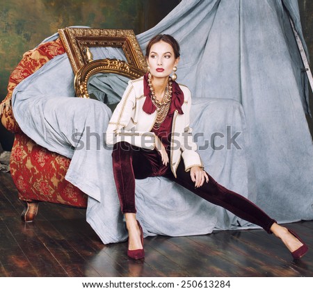 beauty rich brunette woman in luxury interior near empty frames, vintage elegance, gold close up