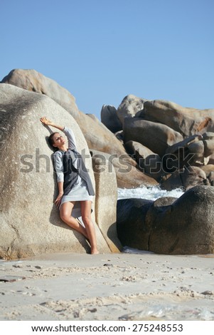 beauty young woman among rocks at sea dreaming relaxing, fancy clothes