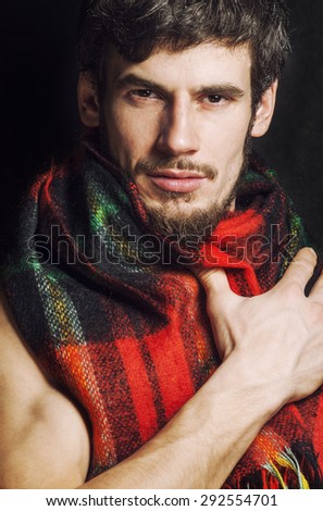 portrait of handsome man warmed up in scarf christmas colored, smiling closeup