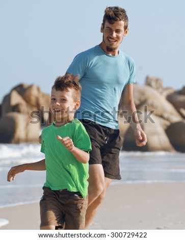 happy family on beach playing, father with son walking sea coast, rocks behind smiling enjoy summer vietnam
